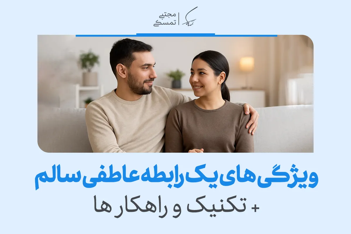 زوجی نشسته روی مبل با لبخند و نگاه صمیمی؛ نمادی از محبت و اعتماد در یک رابطه سالم عاطفی