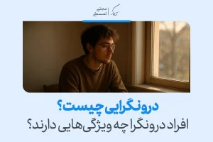 تصویر مردی آرام کنار پنجره که در تفکر عمیق فرو رفته و فضای خلوت و تأمل‌محور درونگرایی را در رفتار روزمره نشان می‌دهد.